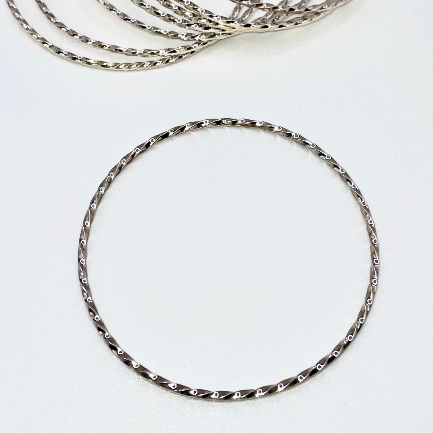 Set of silver bangles on a white background