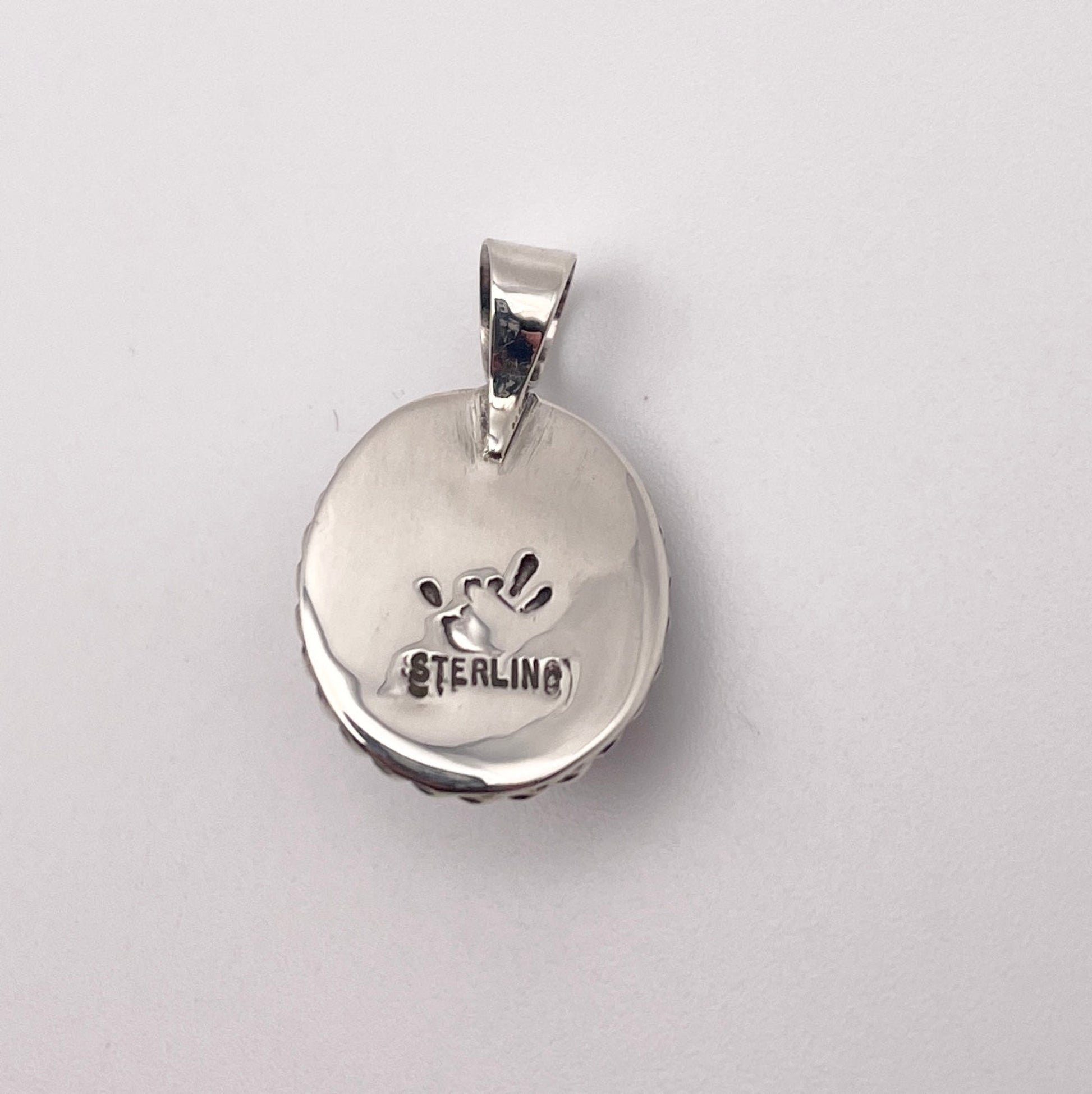 Reverse side of Sterling Silver and rhodonite pendant with STERLING stamp and artist's stamp
