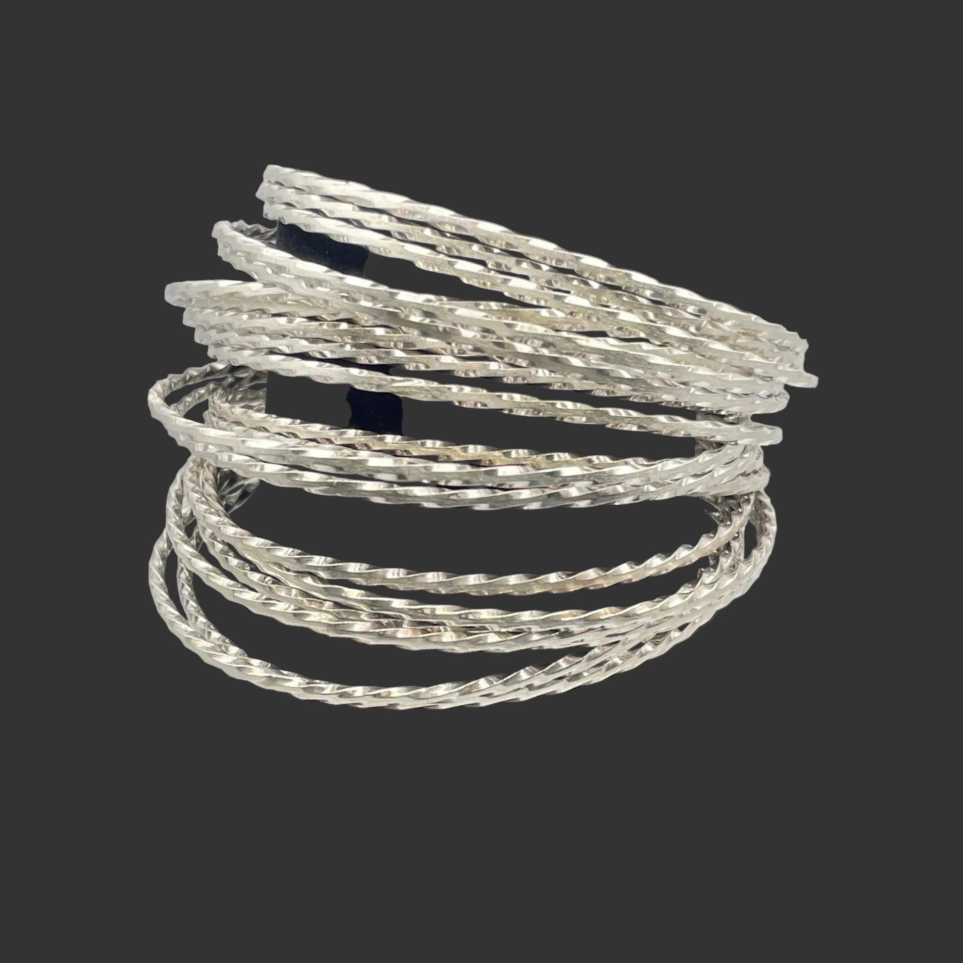A stack of Sterling Silver bangle bracelets shown on a black stand