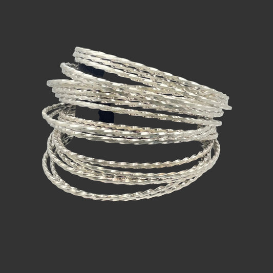 A stack of Sterling Silver bangle bracelets shown on a black stand