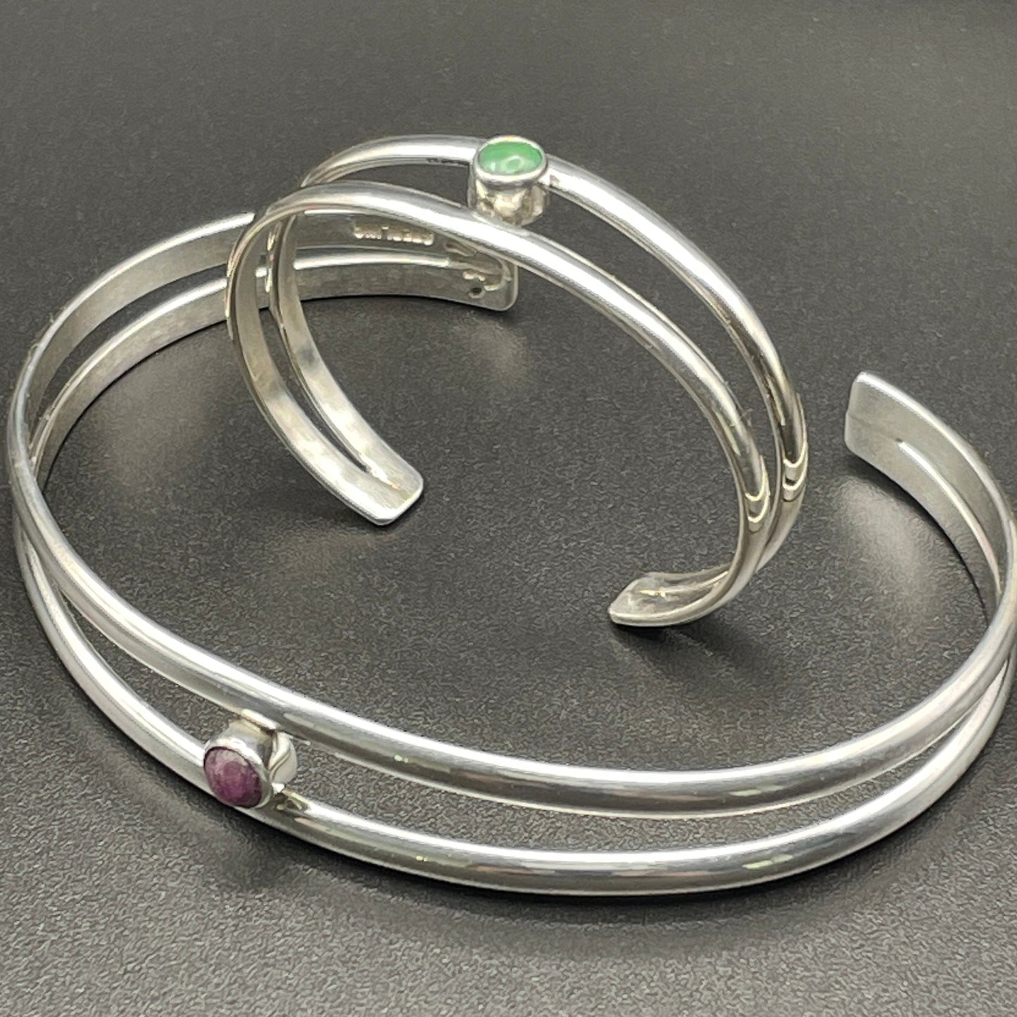 Sterling Silver baby Bracelet sits inside an adult bracelet both featuring birthstones by artist Caleb Calles 
